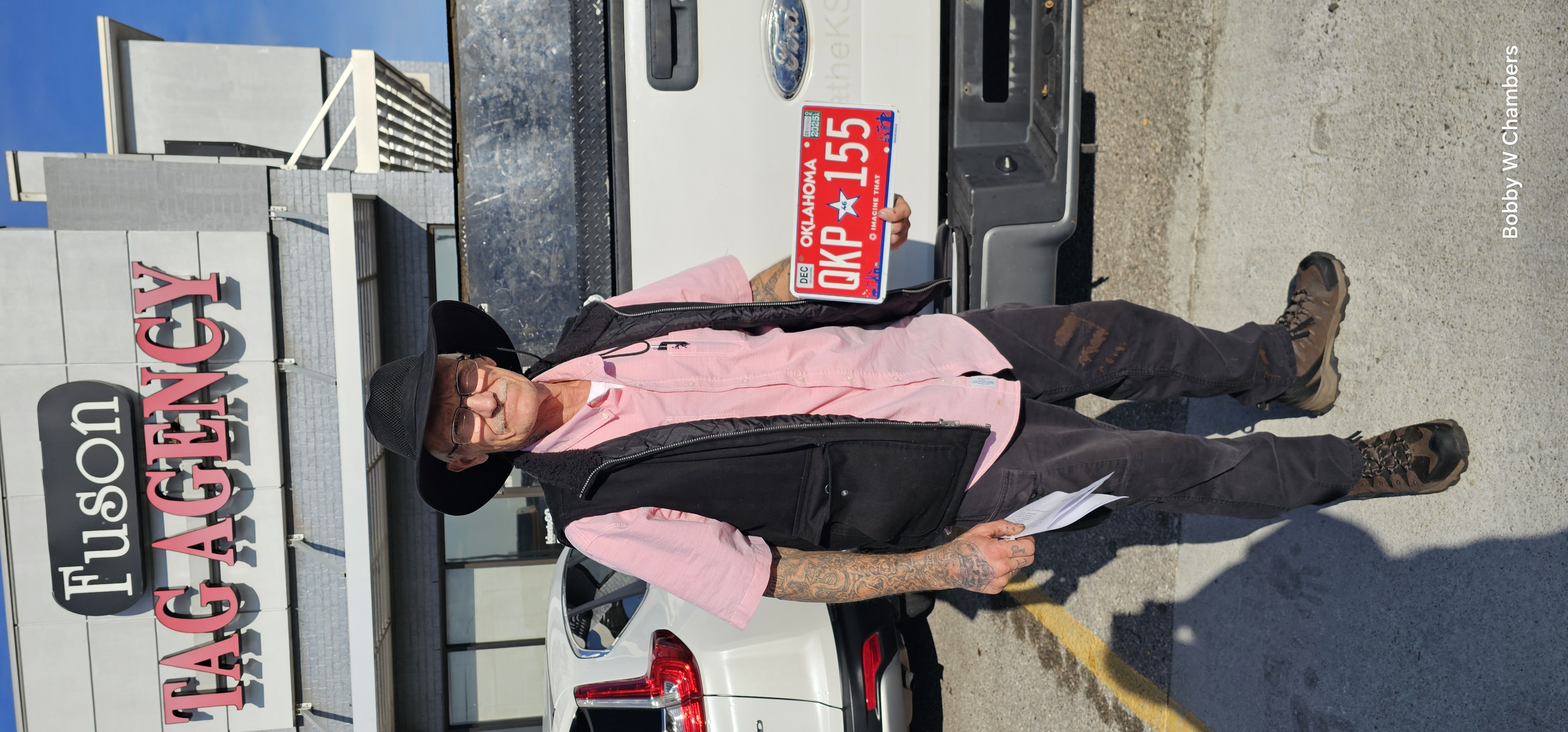 Lonnie holding his Oklahoma license plate